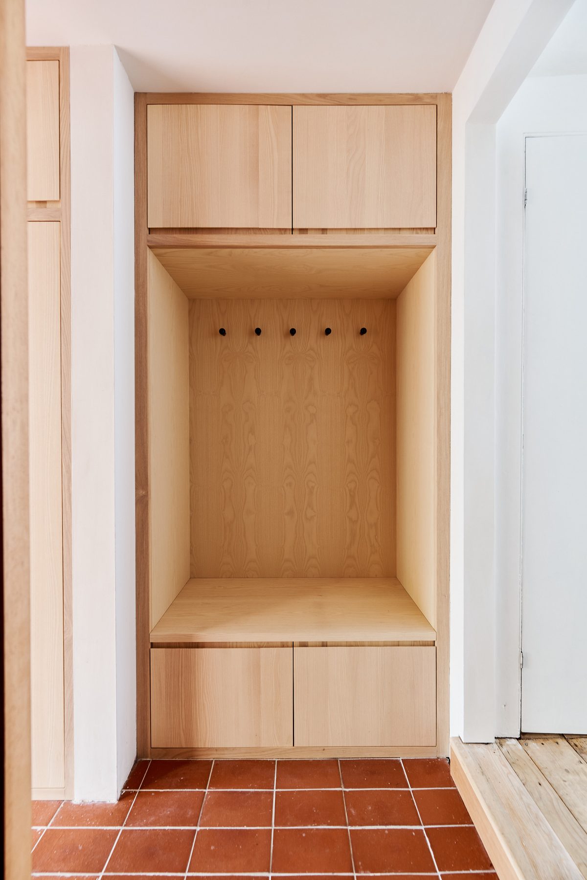 Plywood joinery niche with hanging pegs