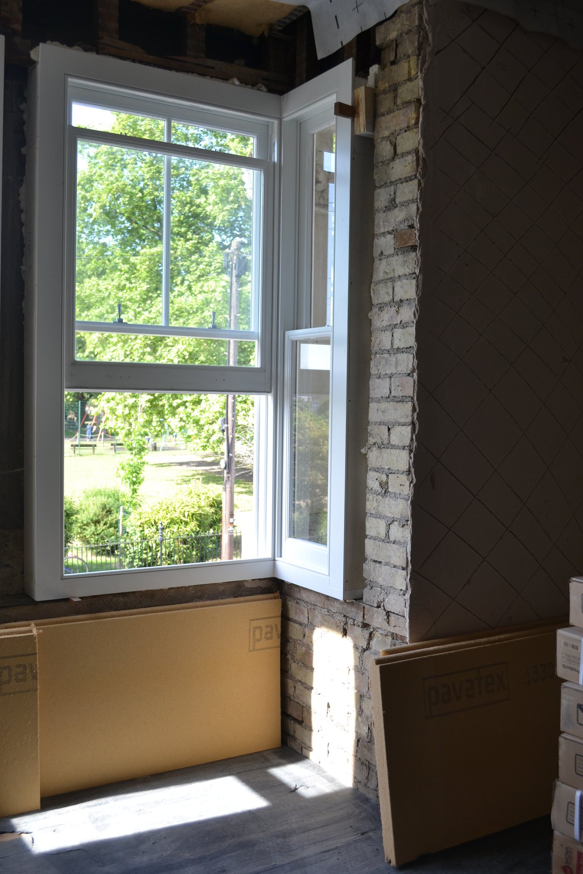 New window junction with wood-fibre insulation in a brick reveal