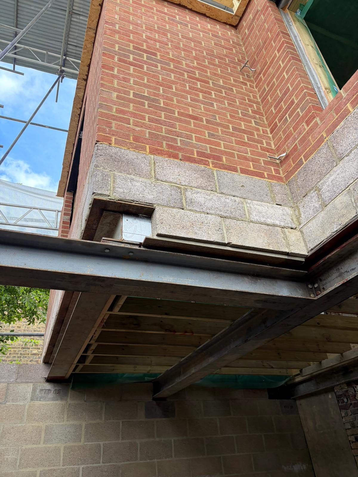 Steel and brick structural junction against sky